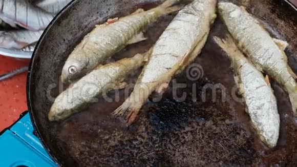 撒上面粉的小鱼用热油在锅里炒露营钓鱼时做饭特写镜头视频的预览图