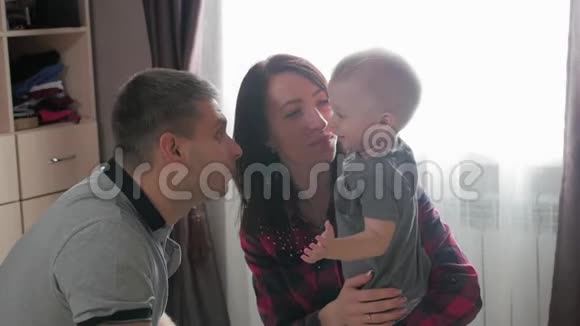 家庭父母和人的概念快乐的母亲和父亲在家玩小婴儿视频的预览图