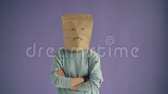一幅悲伤的人的画像脸上戴着纸袋双臂交叉站立视频的预览图