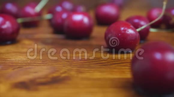 成熟的红樱桃落在带有水滴的木桌上视频的预览图