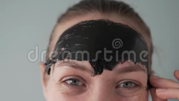 一个女人从她的额头上取出黑色胶卷面具的遗骸视频的预览图