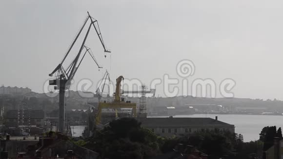 日落时船坞里的鹤亚得里亚海的港湾码头的起重钻机油台和集装箱起重机船舶港口工业视频的预览图