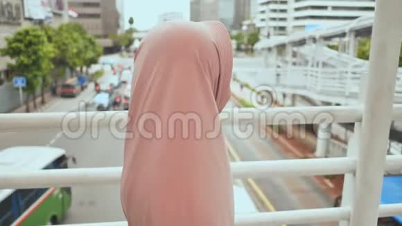 一个微笑的穆斯林女孩正走在过渡道路上印度尼西亚视频的预览图