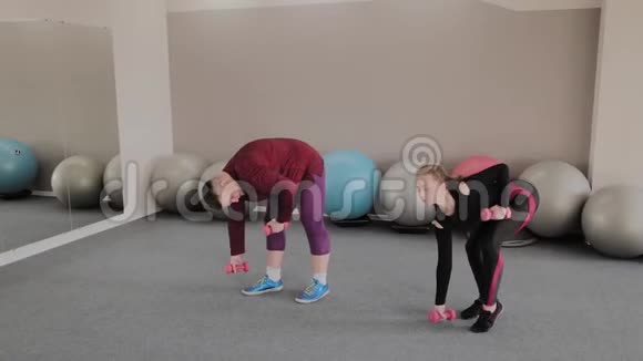 积极超重的女人和健康的男人在地板上做运动有趣的学习视频的预览图