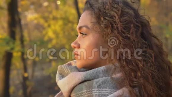 一幅白种人卷发女子的肖像在秋天她正认真地看着远处的景色视频的预览图