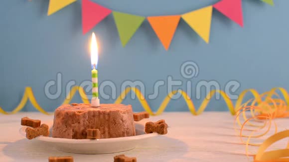 狗的生日快乐蛋糕用湿食物和蜡烛在蓝色聚会背景下享用视频的预览图