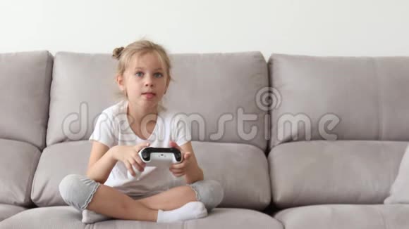 没有牙齿的金发女郎穿着白色T恤玩电子游戏视频的预览图