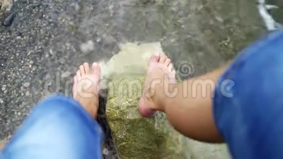 人脚被海浪冲刷那家伙光着脚站在石滩上视频的预览图