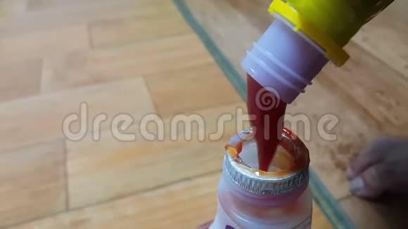 从黄色瓶子倒入小瓶子的红色番茄酱的顶部视图视频的预览图