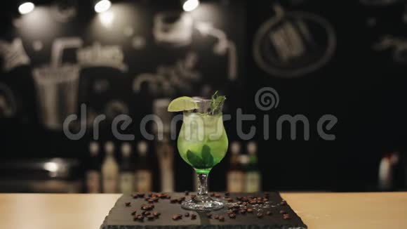 一杯被隔离在酒吧柜台上的处女莫吉托酒保把一根绿色的稻草放进饮料里视频的预览图