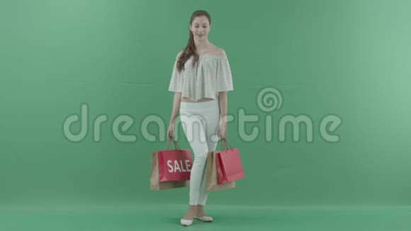 充满欢乐的女性顾客在绿色屏幕上摆着袋子视频的预览图