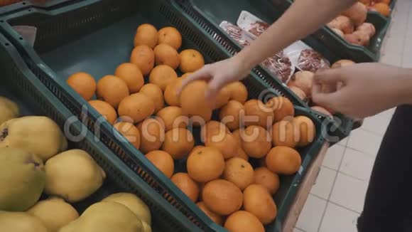 一个女孩在市场上选择橘子视频的预览图