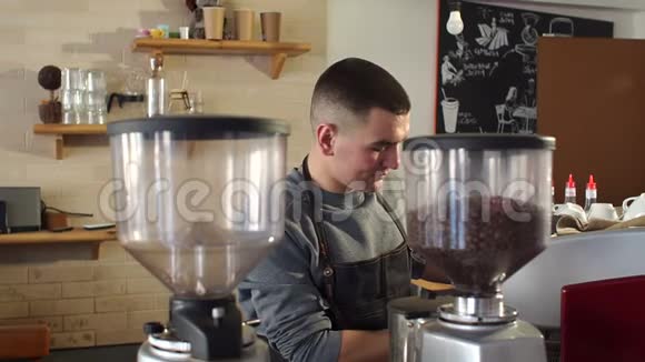 一位英俊的年轻人在现代咖啡店工作时的肖像视频的预览图