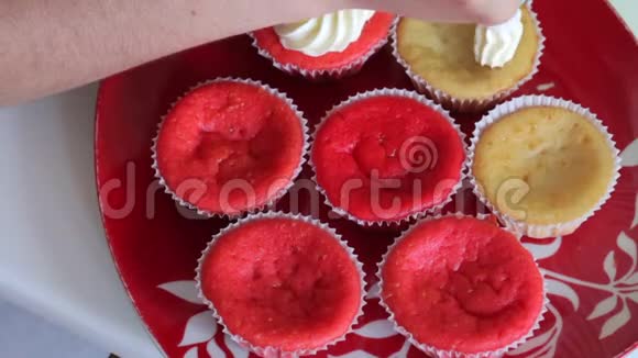准备蛋糕红丝绒的女人用糕点袋涂抹奶油成品蛋糕在盘子里特写镜头视频的预览图