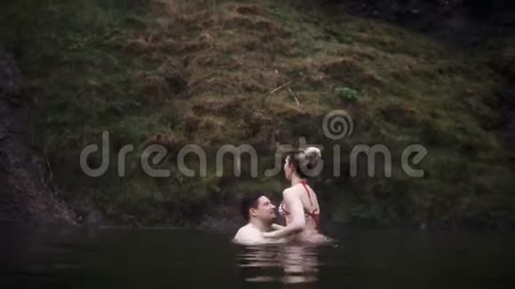 年轻漂亮的夫妇在游泳时一起玩得很开心冰岛温泉的男人和女人视频的预览图