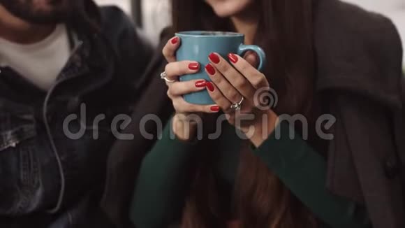 咖啡馆里的年轻夫妇玩得很开心女孩一边和男朋友说话一边喝热咖啡视频的预览图