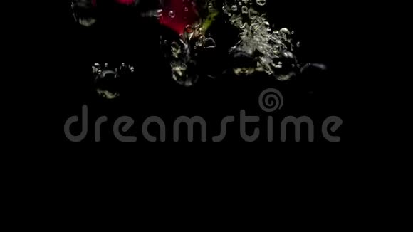 蓝莓草莓和薄荷叶在黑色背景的透明水中落下视频的预览图