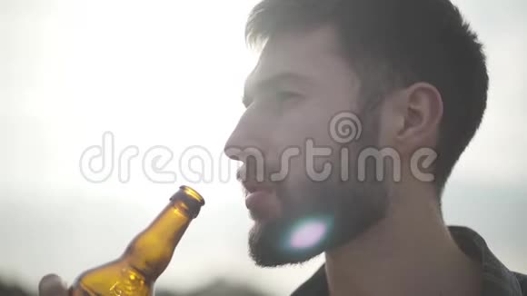 肖像吸引人的胡须男人喝啤酒享受户外饮料一个男人从瓶子里喝啤酒视频的预览图