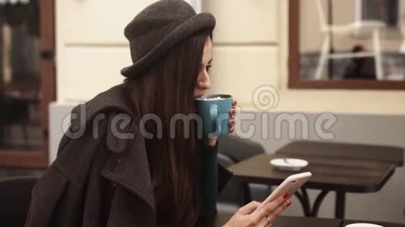 美丽的女孩在咖啡馆里使用智能手机在社交媒体上发短信享受移动技术的放松和放松视频的预览图