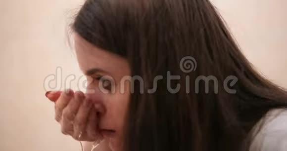 悲伤沮丧的长发黑发女人站在浴室的镜子前哭泣4公里视频的预览图