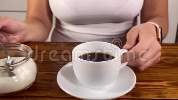 女孩拿着勺子往杯子里放糖视频的预览图