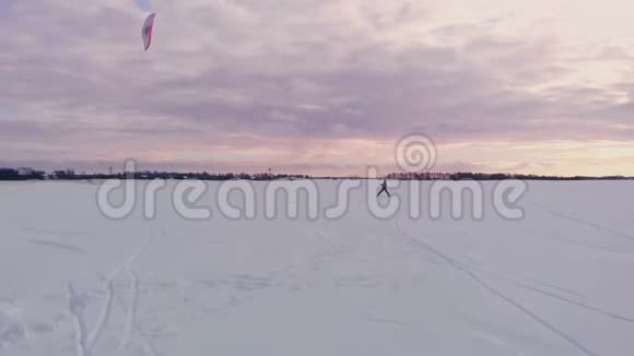 冬天日落时在冰冻的湖面上风筝冲浪视频的预览图