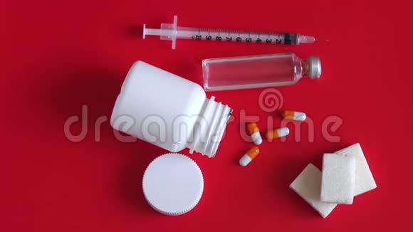 胰岛素注射器一个安瓿胰岛素和一瓶红色背景的药丸视频的预览图