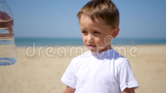 那孩子喝了一瓶水然后开始在沙滩上喝水视频的预览图