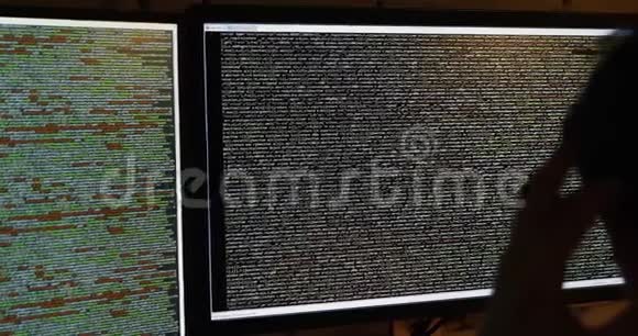 程序员在黑暗的房间里工作电脑屏幕上滚动程式码视频的预览图
