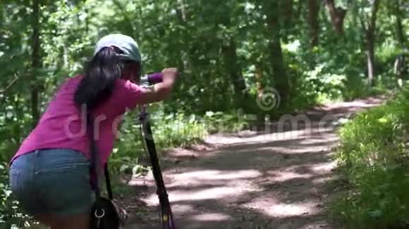 亚洲小女孩在公园里骑滑板车白天视频的预览图