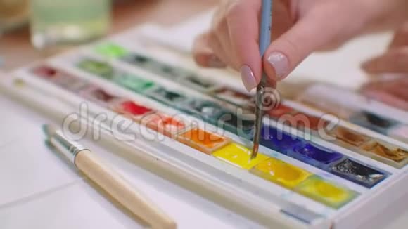年轻女性用画笔和颜料制作配色为设计创造配色视频的预览图