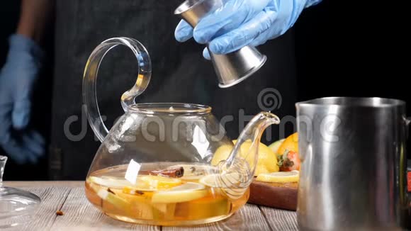 用酒精配制热茶在装有有机水果的玻璃茶壶里倒入热红葡萄酒慢动作视频的预览图