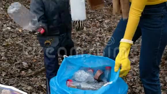 女志愿者带着她的孩子清理河边的垃圾生态和环境概念视频的预览图