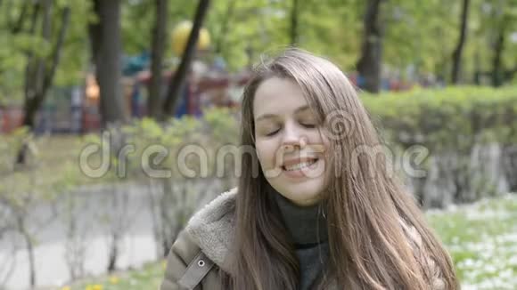 城市公园里迷人的微笑的白种人年轻女子肖像视频的预览图