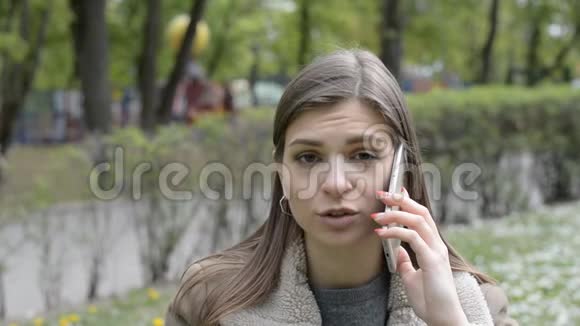 一个在智能手机上说话的悲伤女孩的肖像视频的预览图