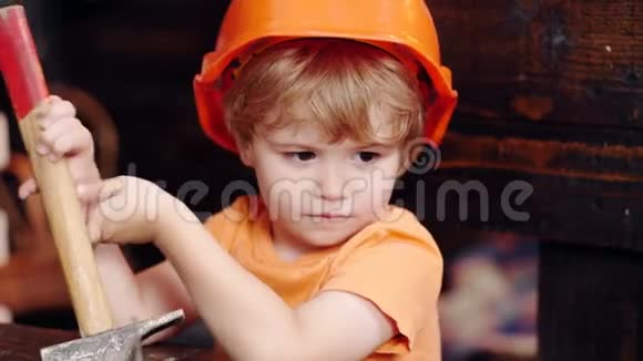 家庭观念车间里的小男孩孩子学习堵塞钉子有工具的男孩忙碌的男孩建筑工人视频的预览图