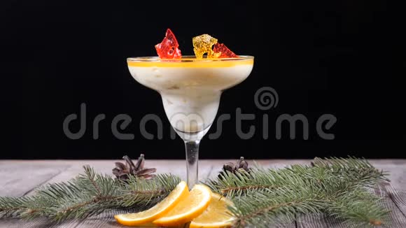 甜点制作概念装饰着冷杉树枝和薄片的木板上的玻璃碗里的美味甜点视频的预览图