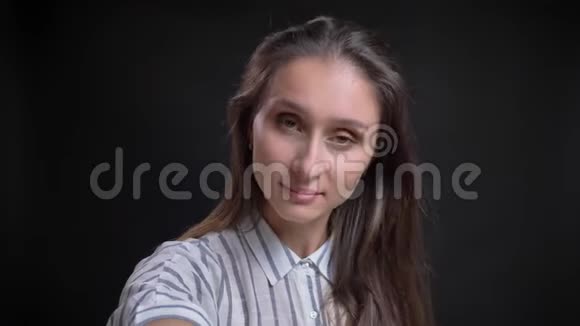 年轻的白种人长发女人在黑色背景下使用智能手机制作自拍照片的自我视频视频的预览图