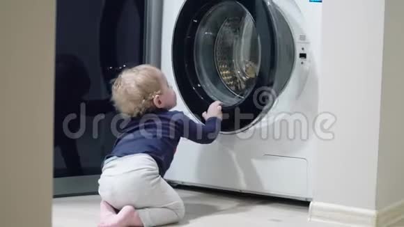 一岁男孩在家看洗衣机家用电器问题小男孩打开洗衣机视频的预览图