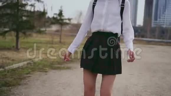 笑着穿着漂亮制服的亚洲女孩放学后在小巷里跳视频的预览图