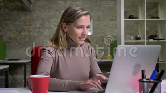 成功的女办公室工作人员在笔记本电脑上打字并因新的胜利而快乐的特写肖像赢家视频的预览图