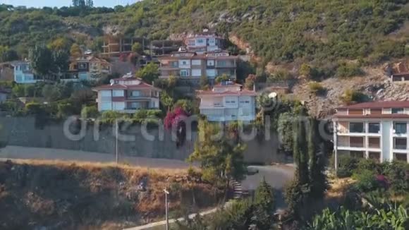鸟瞰美丽的小别墅站在青山上树靠近山路剪辑夏季视频的预览图
