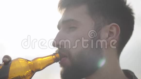 肖像吸引人的胡须男人喝啤酒享受户外饮料一个男人从瓶子里喝啤酒视频的预览图