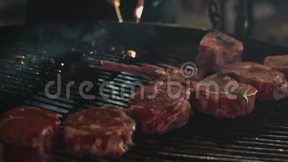 特写男手在外面煮肉厨师把牛肉排骨放在烤架上视频的预览图