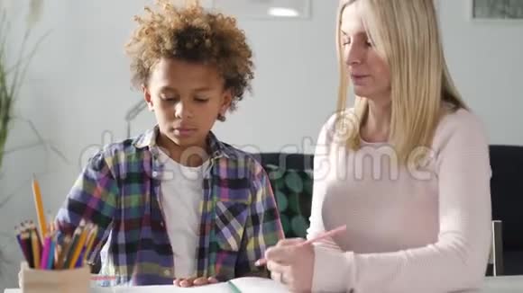 女人和她的小儿子一起准备家庭作业视频的预览图