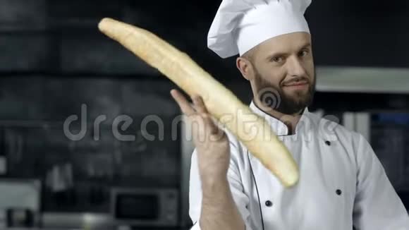 厨师在厨房用法式面包逗乐特写男手玩面包视频的预览图