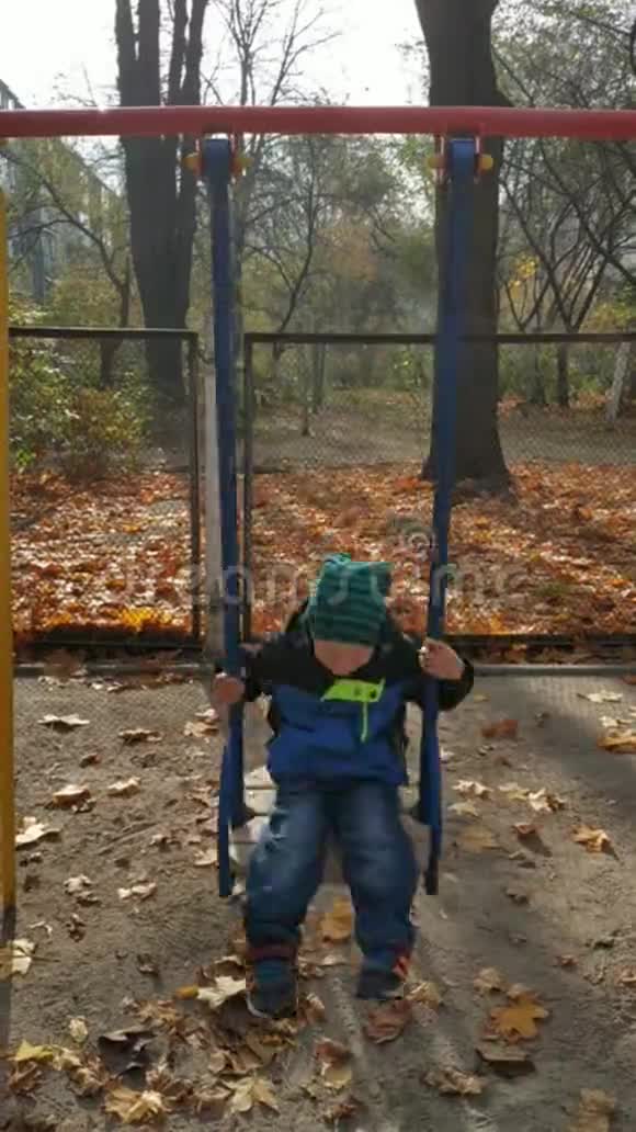 秋天的下午一个孩子正骑在秋千上儿童秋千视频的预览图