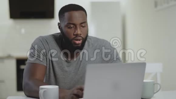 集中的黑人在开放式厨房工作笔记本电脑视频的预览图