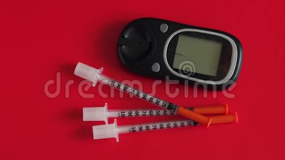 胰岛素注射器和血糖仪用于在红色背景下测量血糖视频的预览图