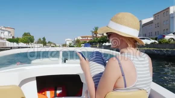 总是连接女人手里拿着电话在船上漂浮在航道上埃姆普里布拉瓦度假小镇视频的预览图